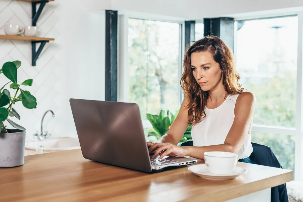 Woman using laptop while sitting at home.